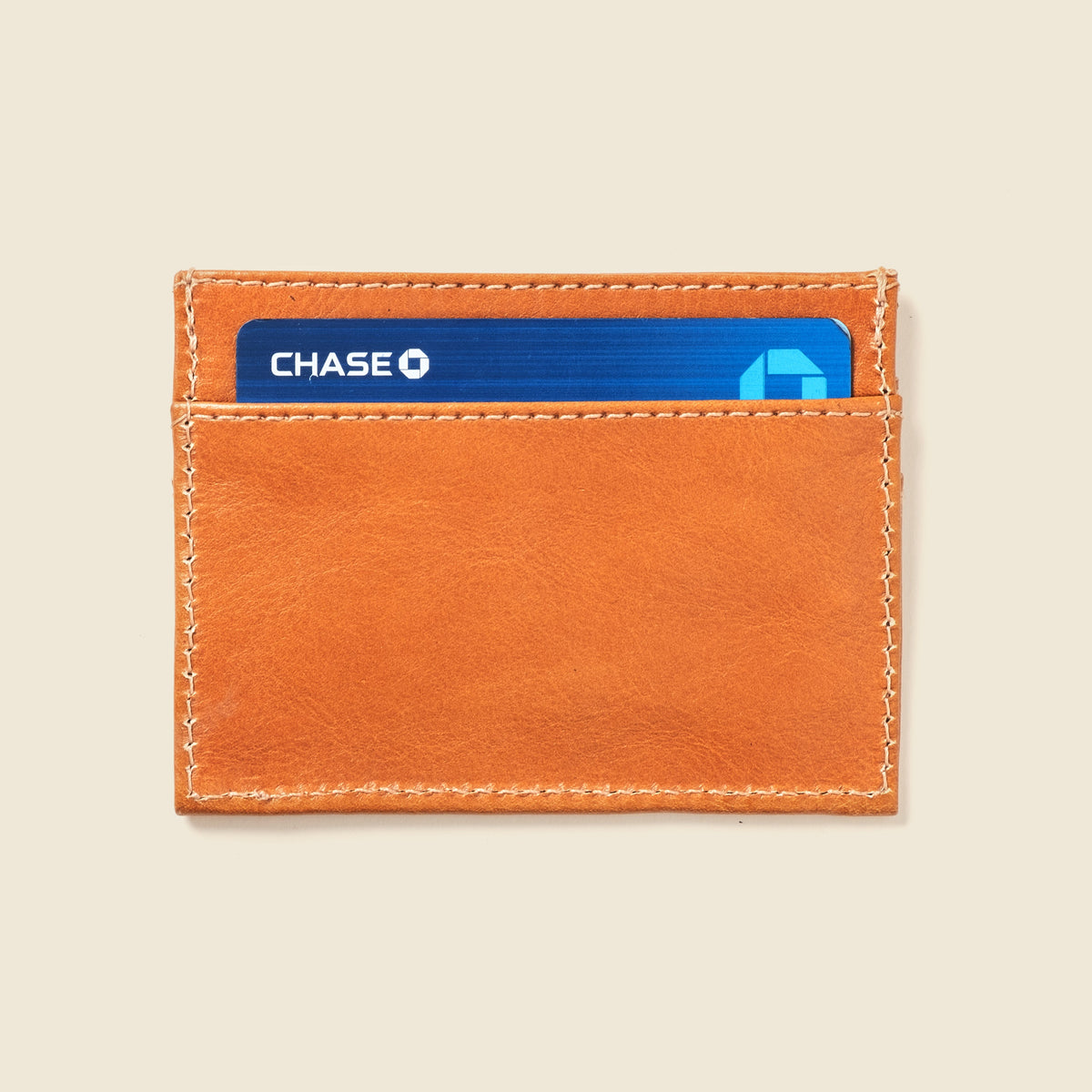 CASUPO slim card holder in natural tan leather, back view holding cards