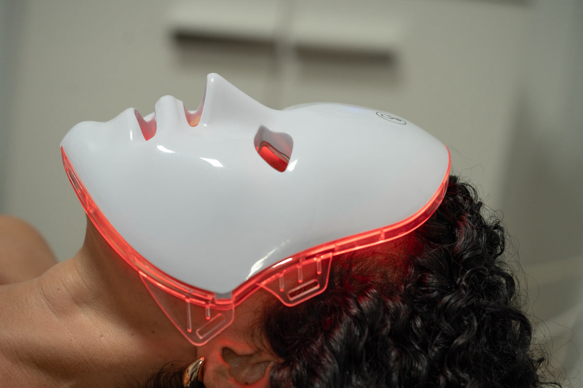 LED light therapy face mask glowing softly during an at-home beauty treatment