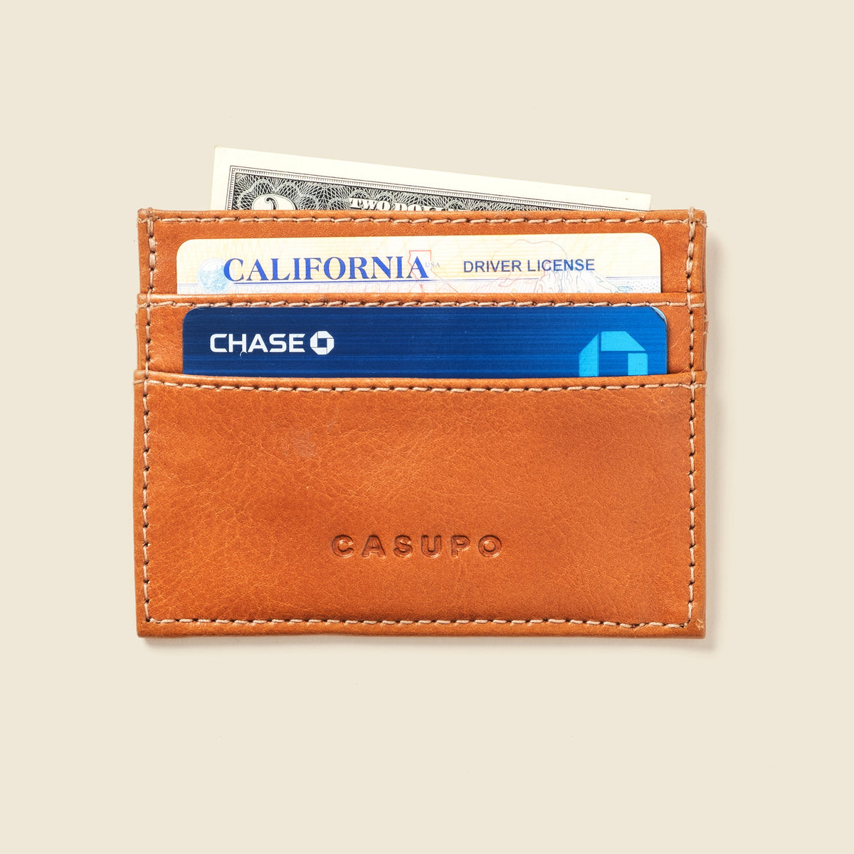 CASUPO slim card holder in natural tan leather, front view holding cards